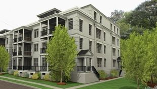 An multi-family apartment building in grey with stone quoins, stacked colonial balconies, and large multi-grid windows.