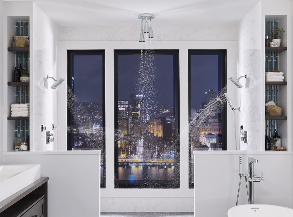 Luxurious shower with three shower heads and no-barrier entry.