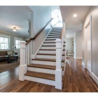 Grand staircase with white pillars and hardwood treads.