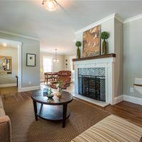 Family room with large fireplace and mantel, hardwood floors, light blue paint.