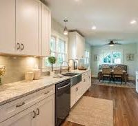 Traditional white kitchen with marble counter top and hardwood floors.