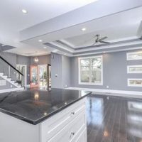 Open concept kitchen design with custom, vaulted ceiling, hardwood floors and a large island.