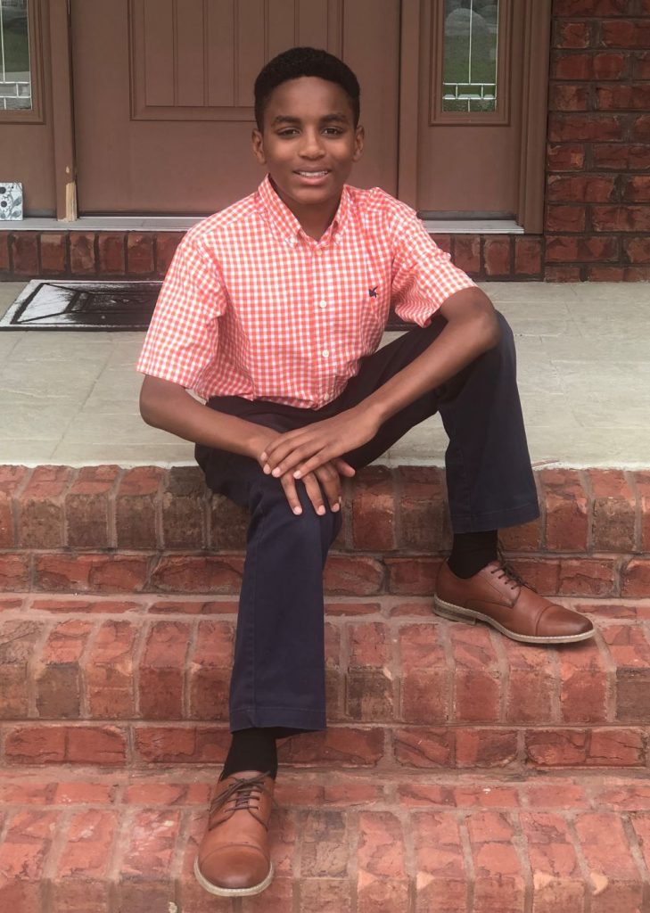 Boy sitting on brick steps.
