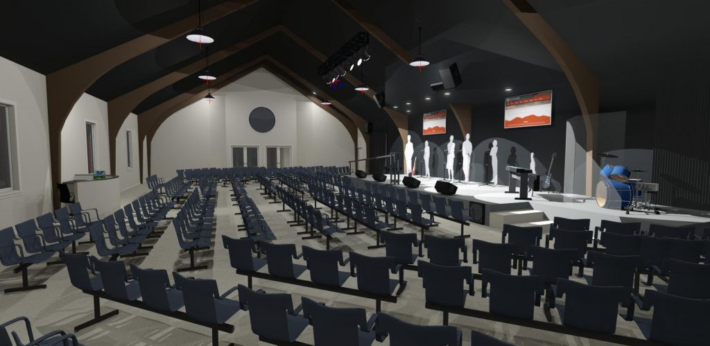 Interior of a church with vaulted ceilings, stadium seating and stage.