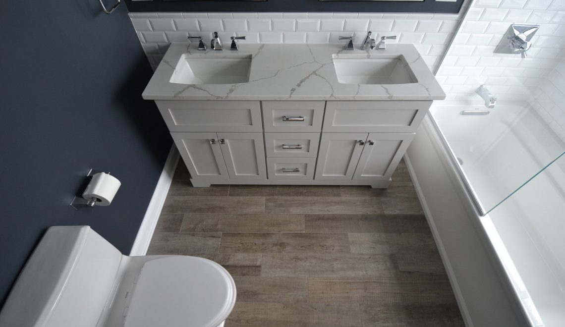 Double sink with blue wall, oak floor, and white backsplash