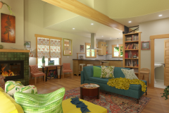 a arts and crafts living room with eclectic decoration, green tile fireplace, vaulted ceiling, overhead beam, looking across to a kitchen